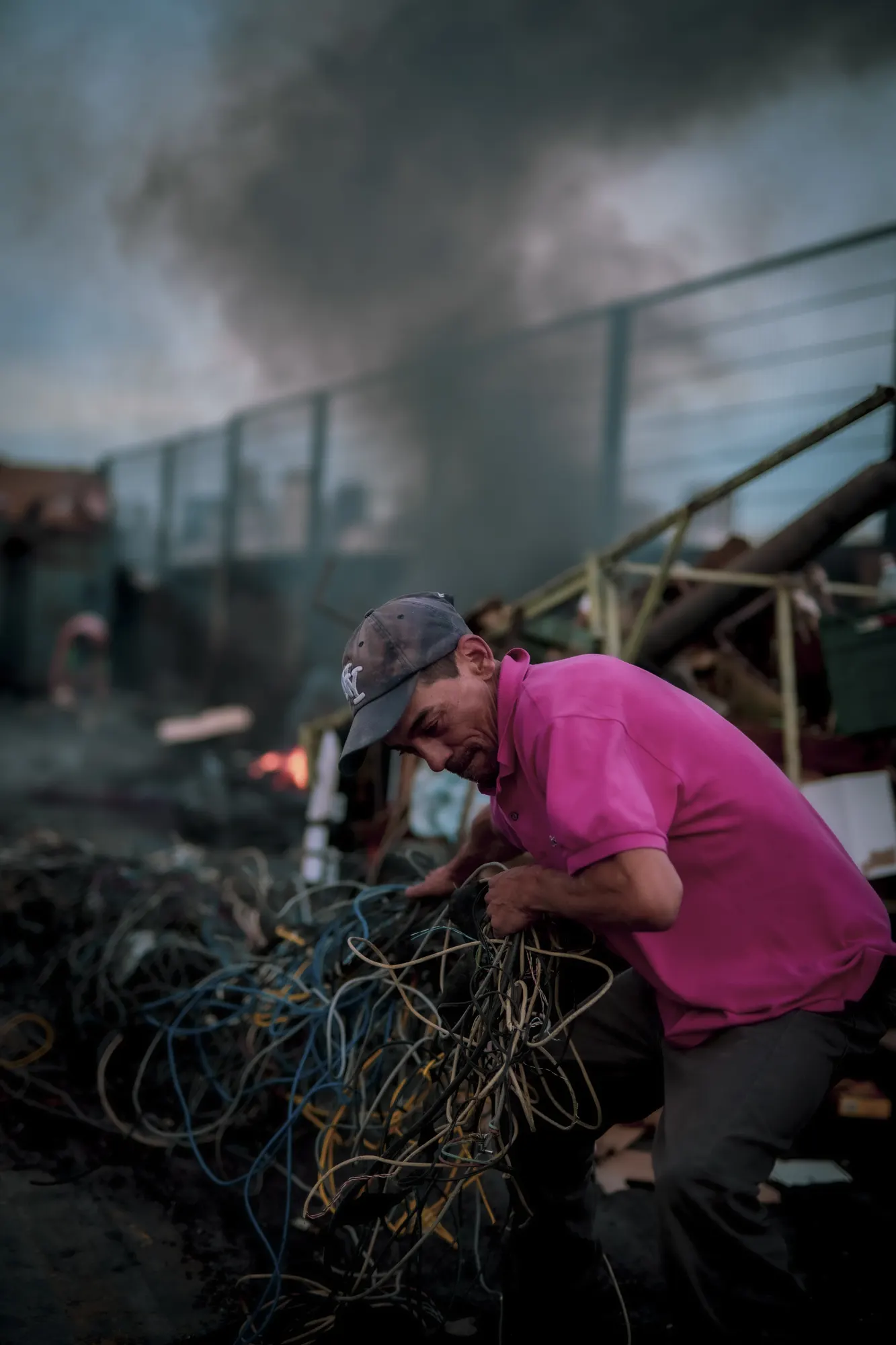 Un hombre separando cables junto a un fuego