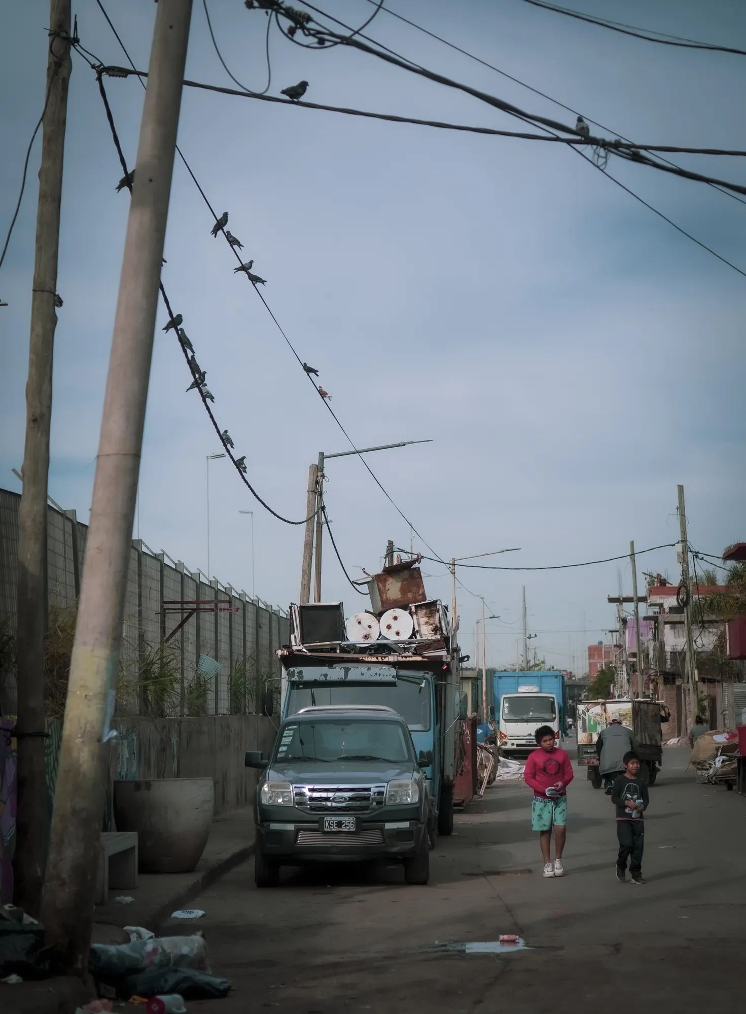 Una calle del barrio con cables cruzados y un camión cargado