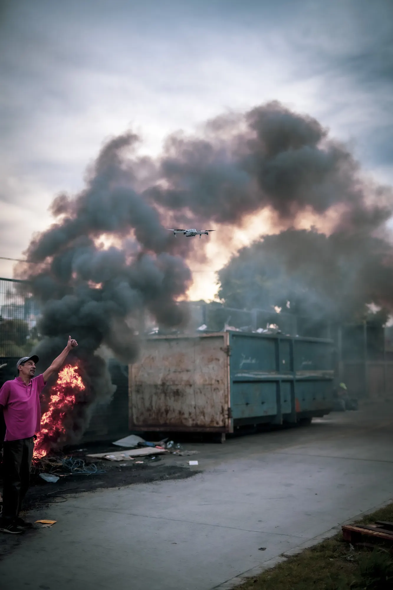 Humo negro sobre un contenedor al costado de la calle